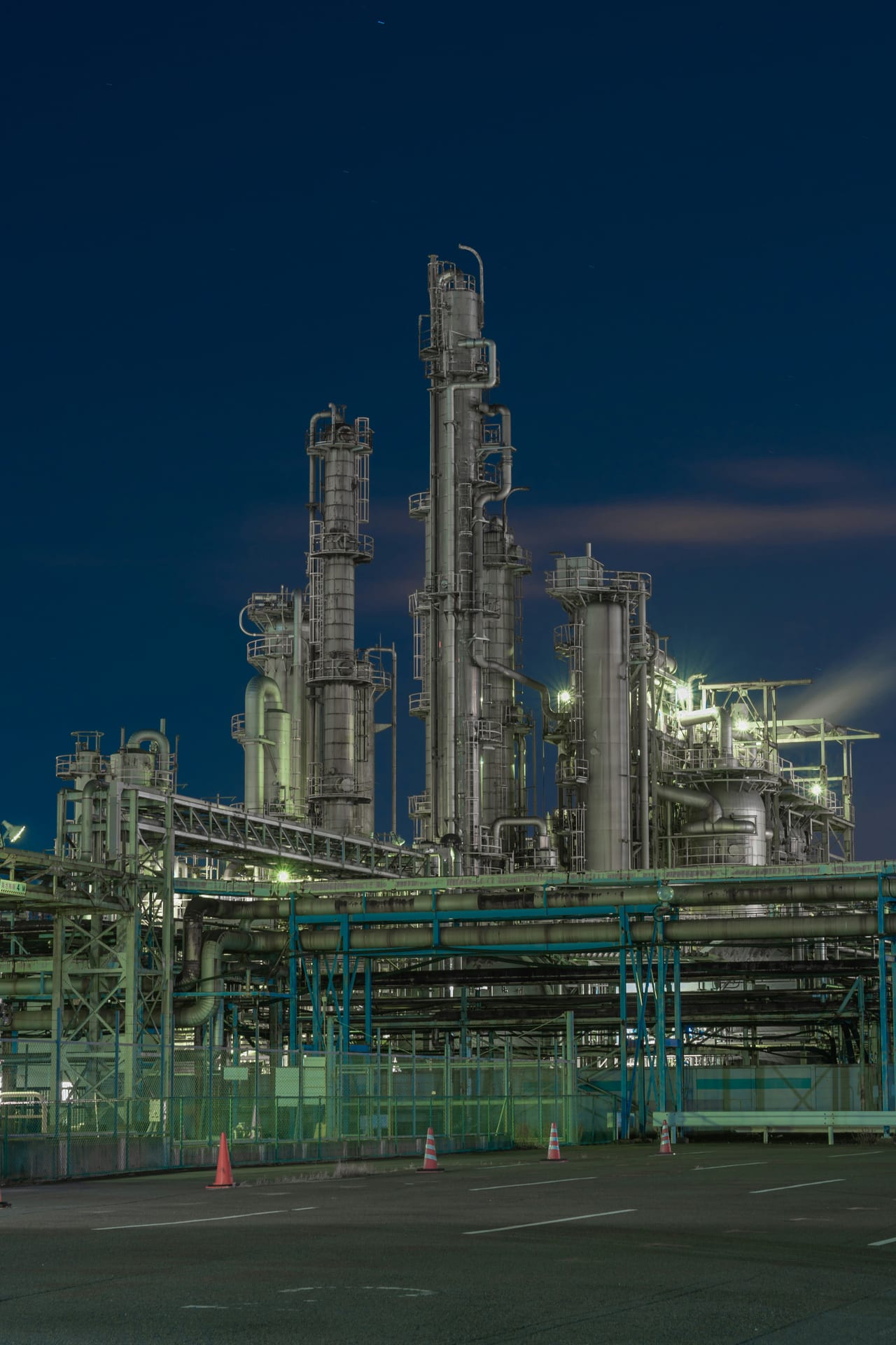 Complexe industriel illuminé la nuit — perspective sur les pipelines et tours du site de Kawasaki.